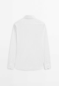 White long-sleeve shirt with a classic collar, buttoned cuffs, and a curved hem. Smooth fabric and minimalistic design. No visible patterns.