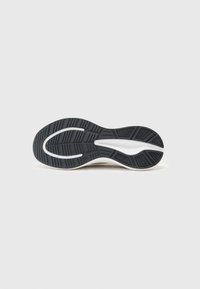 Semelle de chaussure présentant une base en caoutchouc noir avec un motif de prise texturé, un accent blanc au centre et un design ergonomique.
