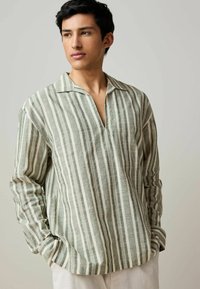 Gestreiftes Langarmshirt in Grün und Weiß, mit V-Ausschnitt und l�ässiger Passform, aus leichtem Stoff mit einer strukturierten Oberfläche.