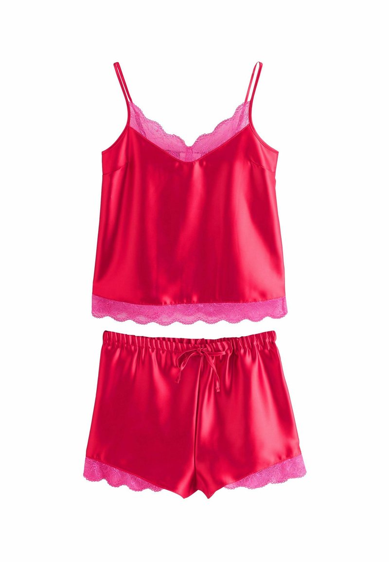 Punainen satiinikankainen camisole ja shortsiyhdistelmä, jossa on vaaleanpunaista pitsireunasta. Camisole on ohutolkaiminen ja siinä on aaltoileva helma; shortseissa on joustava vyötärö.
