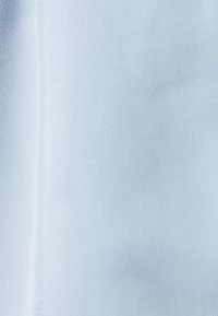 Tejido azul claro con una fina textura diagonal. Apariencia suave y lisa, adecuado para ropa o tapicería. Sin patrones o acentos distintivos.