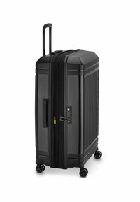 Valigia rigida nera con scanalature verticali, maniglia telescopica, chiusura con zip, lucchetto a combinazione e quattro ruote per la mobilità.