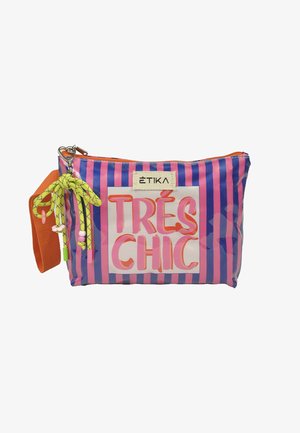 Bolsa de maquillaje a rayas rosas y moradas con cremallera y correa naranja, cordón decorativo amarillo y texto "TRÉS CHIC" en el frente.