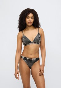 Μαύρο μπικίνι με σχέδιο τζιν, που περιλαμβάνει τριγωνικό μπράλετ και αντιστοιχούντα στρινγκ. Διαθέτει λεπτές τιράντες και διακριτικό ραφής με αντίθεση. Υφή με ανάγλυφη επιφάνεια.