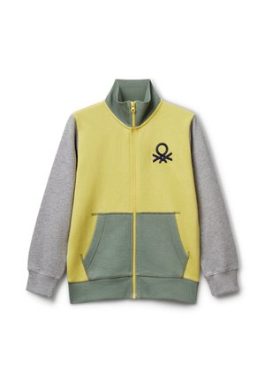Giacca con zip dal corpo giallo, dettagli verdi e maniche grigie. Presenta un colletto alto, due tasche frontali e un logo ricamato blu navy.