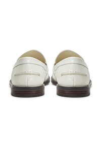 Weiße Lederloafer mit glatter Textur, Nahtdetails entlang der Nähte und einem niedrigen braunen Holzabsatz.