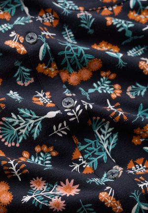 Tume riie, millel on sinakasrohelised lehed ja oranžid lillemustrid, keskel õmmeldud ümarad hallid nupud.