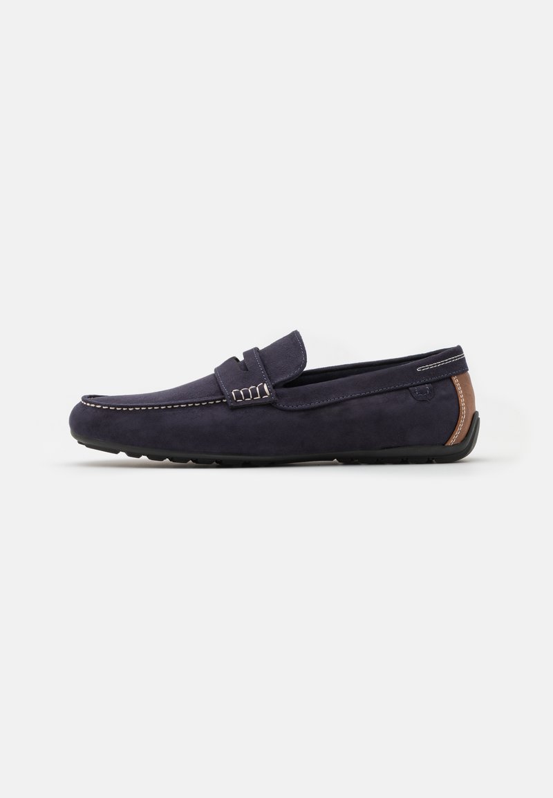 Mocassini in suede blu navy con finitura liscia, design della punta cucito e un dettaglio in pelle marrone sul tallone. Suola in gomma per una migliore aderenza.