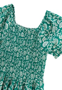 Robe verte avec un motif floral blanc, dotée d'un corsage smocké, d'un décolleté carré et de manches courtes. Fabriquée en tissu léger.