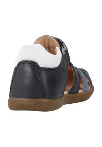 Námořnické kožené sandály s bílými akcenty, otevřený design vystavující modré pásky, polstrovaný zadní díl a hnědou gumovou podrážku s logem "GEOX".