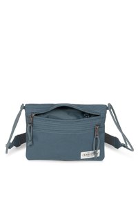 Bolso de bandolera de tela azul con un compartimento principal con cremallera y un bolsillo frontal, que cuenta con una correa ajustable y una etiqueta de logo en el lateral.