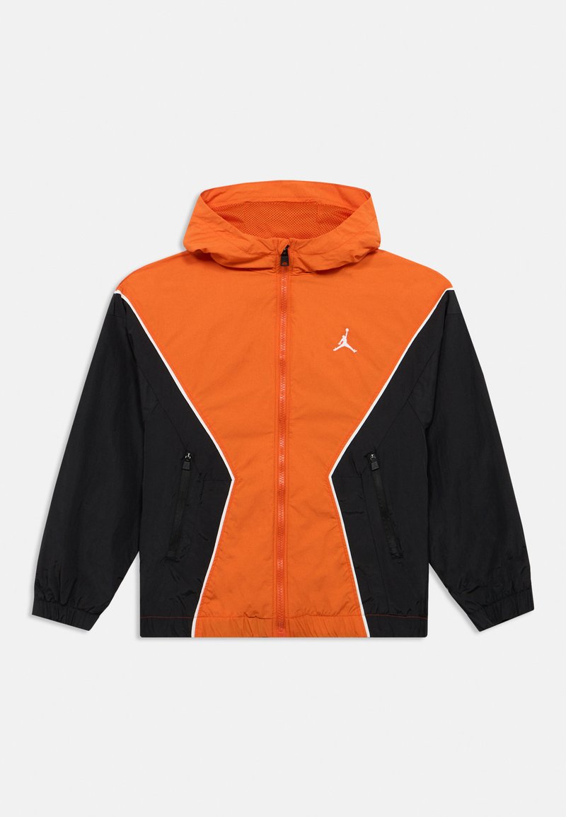 Oranžs un melns vēja žaktes ar kapuci, ar priekšējo rāvējslēdzēju, sānu kabatām un baltām accent līnijām. Ietver logotipu uz krūšu daļas.