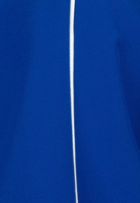 Blått tyg med en slät textur, med en vit vertikal rand för kontrast. Designen är enkel och ren, vilket framhäver den livliga färgen.