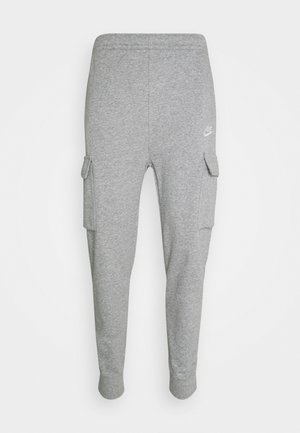 Grijze Nike joggingbroek met elastische boorden, zijvakken met kleppen en een klein wit Nike-logo op de rechterdij.