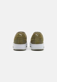 Green suede sneakers with a textured finish, featuring a white rubber sole and simple white logo accents on the heel and side.