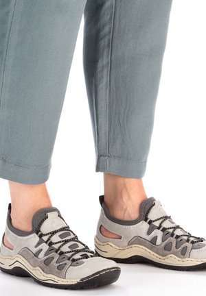 Gray and beige athletic shoes with mesh panels, textured surfaces, and a rounded toe. Laced with dark cords and a rubber sole.