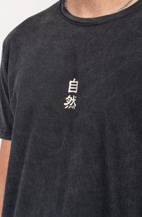 Juodas medvilninis marškinėliai su apvaliu kaklu, ant priekinės dalies turi spausdintus baltus japonų ženklus. Minkšta tekstūra su šiek tiek dėvėtu įvaizdžiu.
