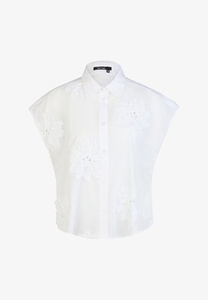 Weiße kurzärmelige Bluse mit Knopfleiste, Kragen und großen gestickten Blumenmustern auf der Vorderseite und den Ärmeln.