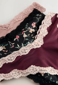 Damesondergoed met kantafwerking in zwarte, bordeauxrode en blush kleuren, met bloemmotieven en delicate kantaccenten.