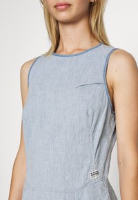 Ärmlös denimklänning i ljusblått med en subtil textur, med en bröstficka och G-Star-märket på sidan.