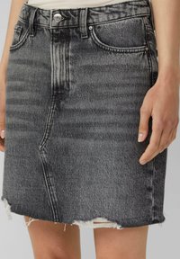 Grijze denim rok met een ruwe zoom, vijf zakken en zichtbare stiksels. Vervaagde textuur met lichte en donkere contrasten. Strak aansluitend ontwerp.