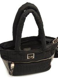 Zwarte gestoffeerde tote bag met dubbele handvatten, een gouden logo-accent en een grijze paneel met een ritsvak en dierenprintdetail.