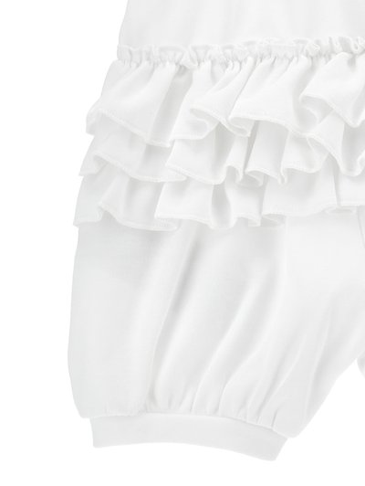 Robe blanche avec des volants, fabriquée en tissu doux. Elle possède une taille élastique et des manches bouffantes, ajoutant du volume et de la texture.