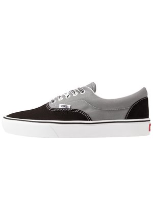Lavtop Vans sneaker i sort og gråt lærred med hvide snørebånd, hvid gummisål og Vans logotags på siden og i tungen.