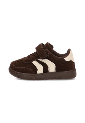 Zapatilla infantil marrón con rayas blancas en zigzag, tira de velcro, cordones y suela de goma texturizada, vista de lado.