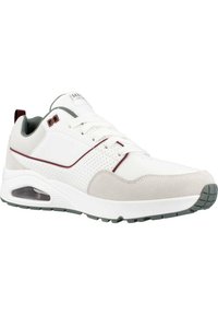 Chaussure de sport blanche avec accents gris et détails en daim. Présente un dessus perforé, une semelle rembourrée avec une unité d'air visible et une semelle extérieure en caoutchouc.