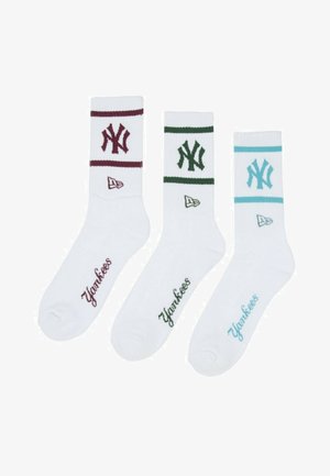Drei weiße Crew-Socken mit "Yankees" bestickt in Burgunder, Grün und Blau, jeweils mit passenden Streifen und dem Logo der New York Yankees.