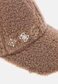 Cappello di tessuto marrone fuzzy con una superficie testurizzata, caratterizzato da tre accenti metallici decorativi di design variabile sul fronte.