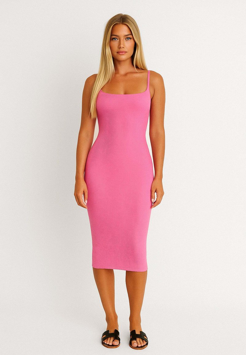 Różowa, prążkowana sukienka midi z cienkimi ramiączkami, dopasowanym krojem i teksturowanym materiałem. Połączona z czarnymi klapkami.