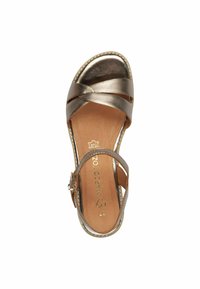 Sandal in bronzo metallico con cinturini incrociati, punta aperta, cinturino alla caviglia regolabile e soletta imbottita. Suola texturizzata con dettagli di cucitura.