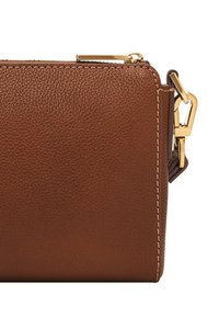 Brun läderväska med texturerad yta, guldfärgad hårdvara och kontrasterande sömmar. Har ett dragkedjestängning och en avtagbar rem.