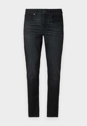 Sötét farmernadrág, slim fit szabásban. Jellemzői közé tartozik öt zseb, cipzáras nyitás, gombos záródás és diszkrét varrási részletek.