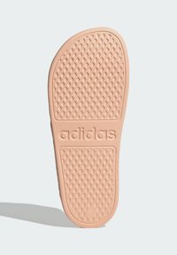 Sole sandałów Adidas w jasnoróżowym gumie; teksturowana wzorem diamentowym; posiada wytłoczone logo oraz gładkie krawędzie.