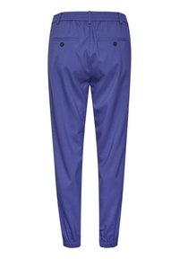 Vue arrière d’un pantalon bleu avec une taille élastique, deux poches arrière à boutons et des poignets élastiques aux chevilles.