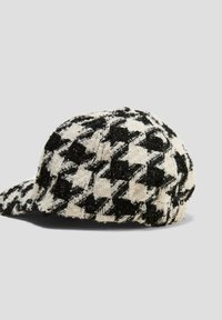 Czarnobiały kapelusz w wzór houndstooth z teksturowanej tkaniny, z okrągłą koroną i wygiętym daszkiem.