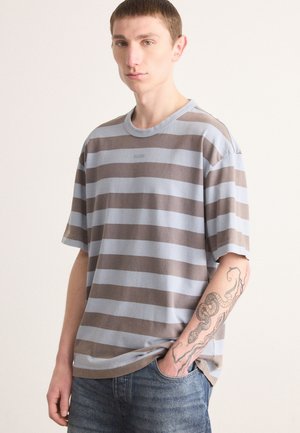 Striped T-shirt in light blue and brown, cotton material, loose fit, crew neck, short sleeves, with subtle logo detailing on the chest.