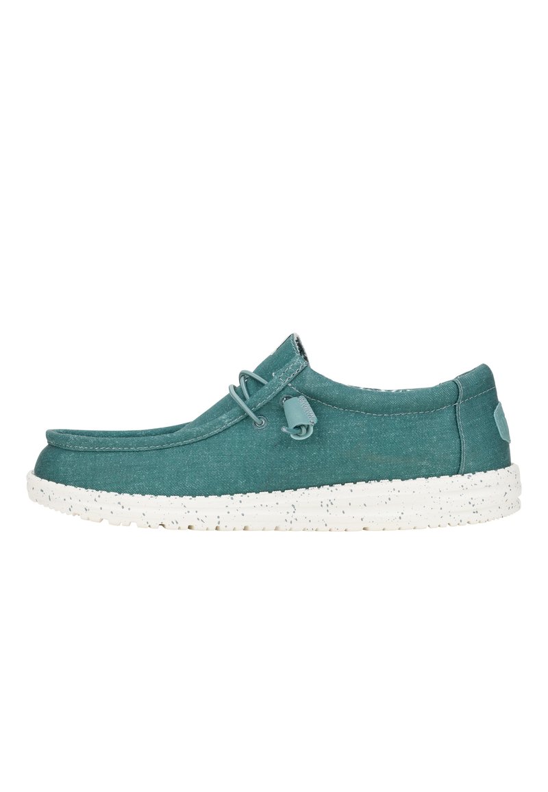 Sneakers slip-on in tela verde acqua con suola bianca maculata, caratterizzate da una cucitura in rilievo, dettaglio ad anello e lacci elasticizzati per una vestibilità sicura.