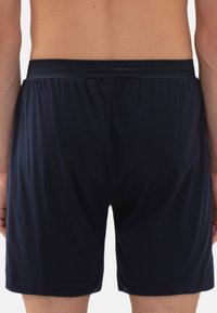 Donkerblauwe herenen onderbroeken van gladde stof met een elastische tailleband, met een eenvoudig ontwerp en zonder zichtbare patronen.