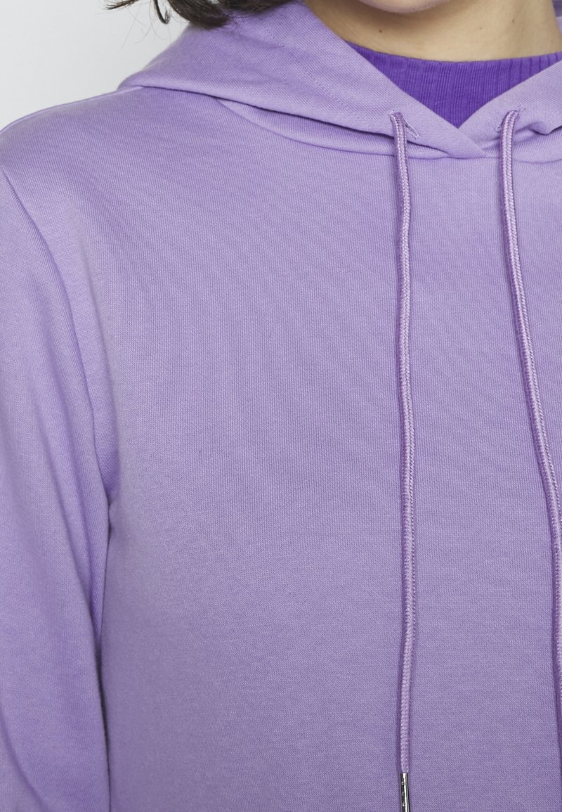 Sweat à capuche violet en tissu mélangé de coton. Comprend un cordon de serrage avec embouts métalliques, texture côtelée autour de l'encolure.