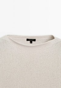 Pull beige en maille avec col rond et une étiquette noire Massimo Dutti cousue à l'intérieur du col.