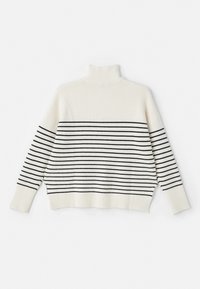 Maglione a collo alto lavorato a maglia di colore crema con strisce orizzontali nere, texture a coste, spalle abbassate e spacchi laterali per facilitare i movimenti.