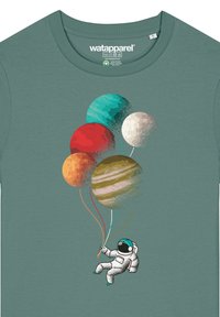 T-shirt en coton vert avec un astronaute tenant des ballons en forme de planètes ; inclut des détails texturés et des couleurs vives comme le rouge, le bleu et l'orange.