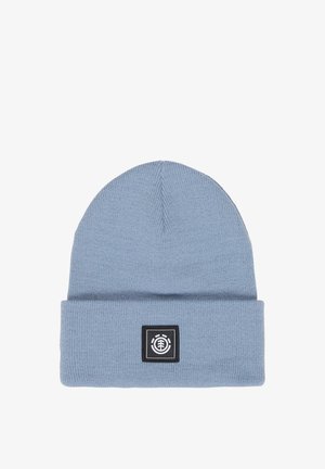 Jasnoniebieska dziergana czapka typu beanie z podwiniętym mankietem, zdobiona czarną kwadratową naszywką z białym, okrągłym logo drzewa.