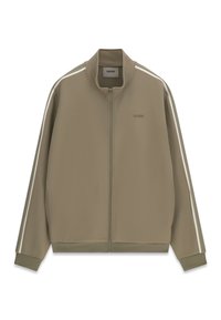Veste de survêtement kaki zippée, avec des bandes blanches sur les manches, des poignets et un ourlet côtelés, et un petit logo « "GUESS" » sur la poitrine gauche.