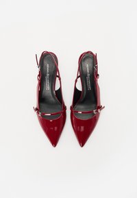 Talons slingback en cuir verni rouge avec un bout pointu, des brides de cheville ajustables et une finition brillante, dotés d'une semelle intérieure noire.