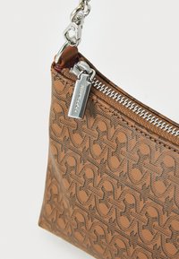 Brown patterned handbag with a silver zipper and chain strap, featuring a logo tag and smooth texture, compact rectangular shape.